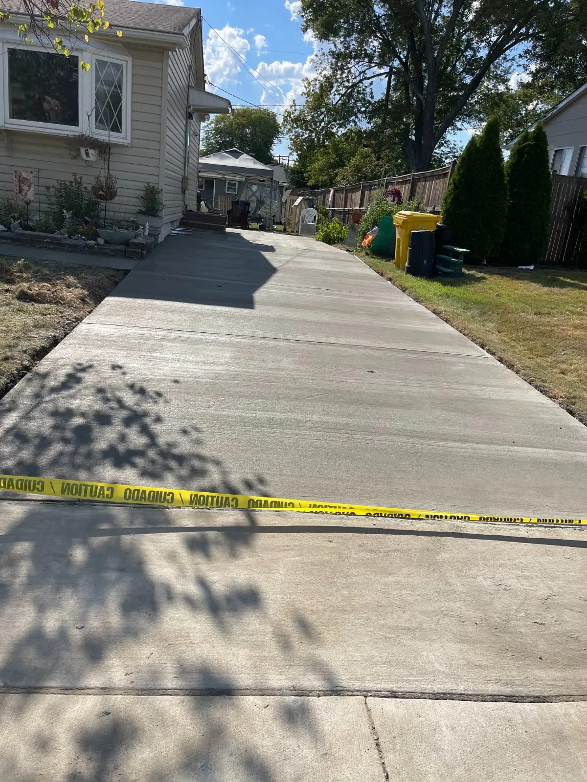 Freshly poured concrete driveway alongside a home