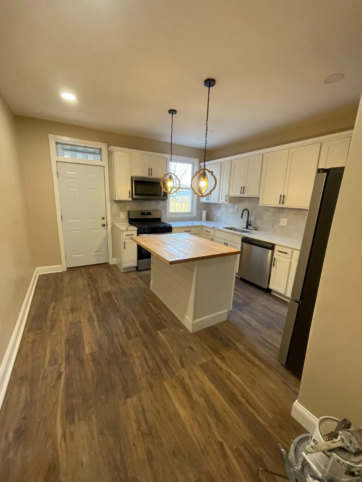 Remodeled kitchen with cream shaker cabinets and butcher-block island