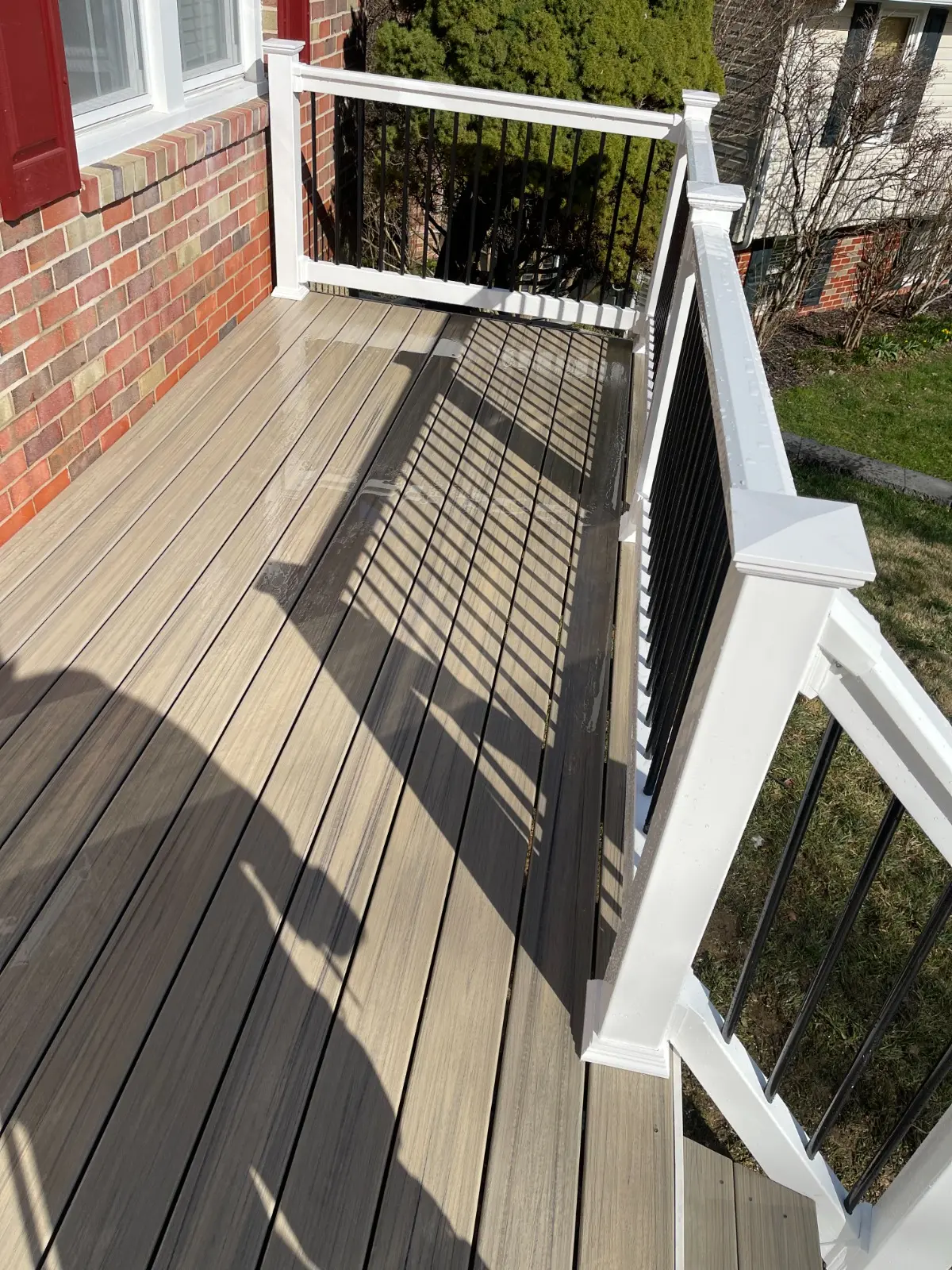 Composite deck boards with white railing and black aluminum balusters
